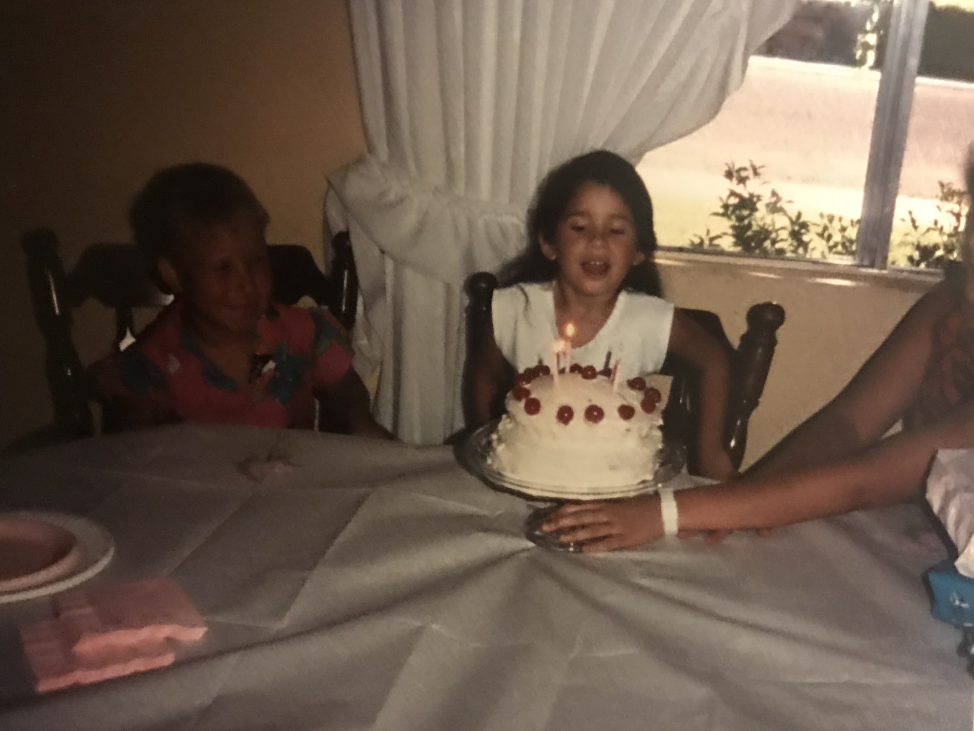 girl blowing out candles on cake