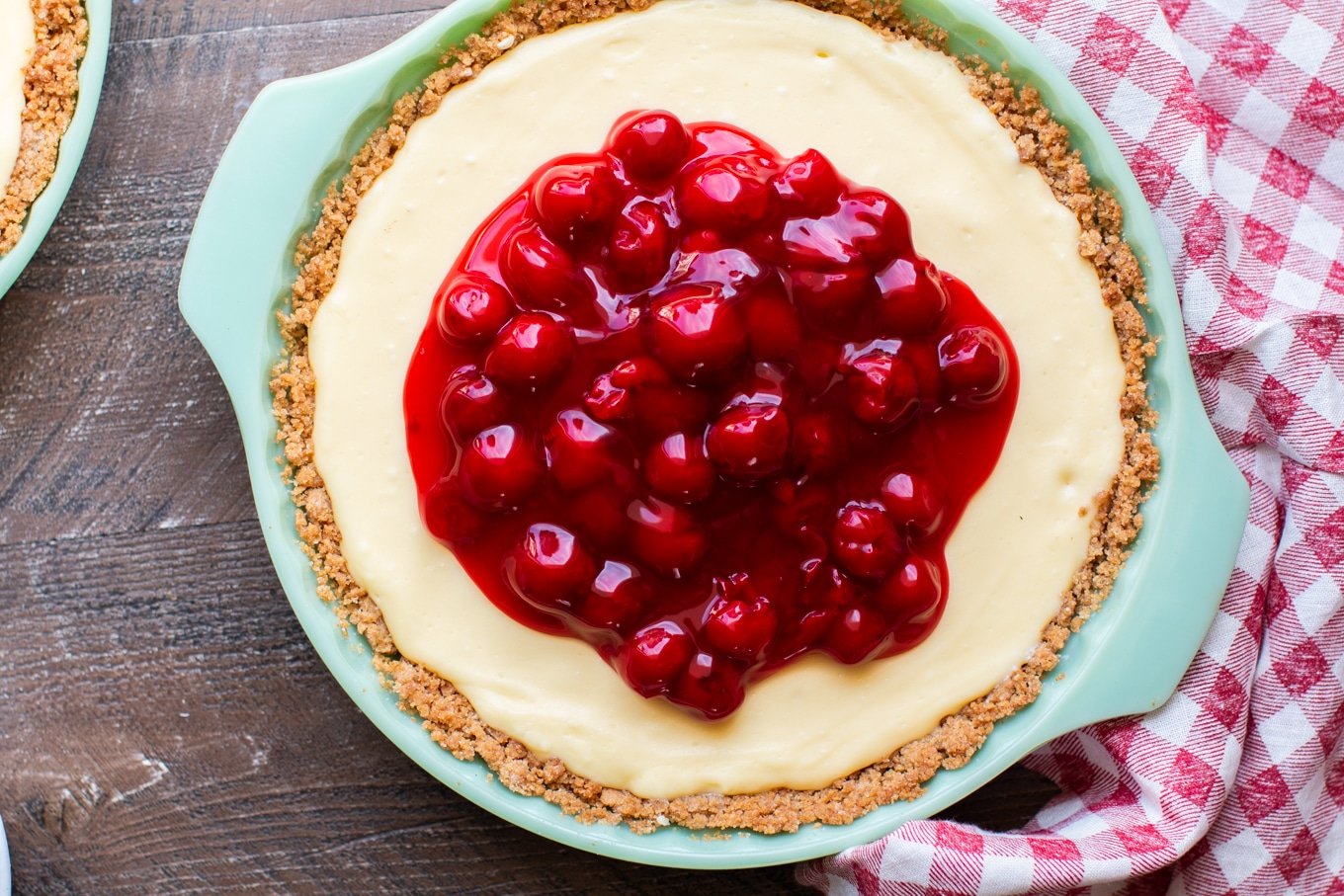 close up of cream cheese pie with cherries on top.