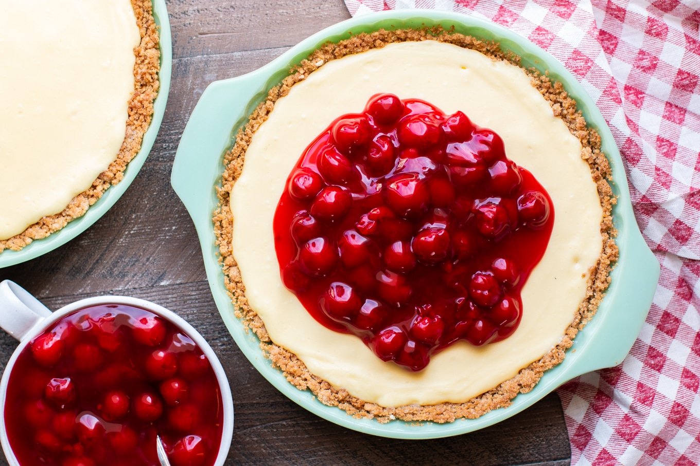 cream cheese pie with cherries on top and cherries on the side.