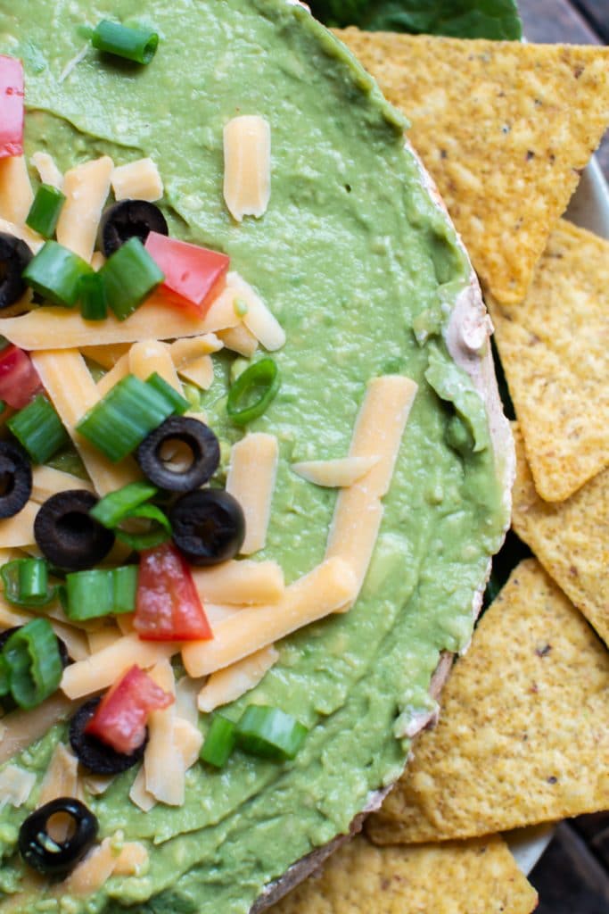 overhead shot of bean dip with guacamole on top.