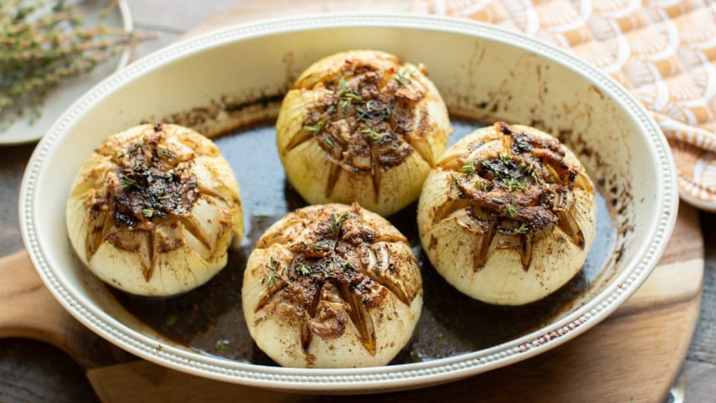 close up of baked onions in baking dish