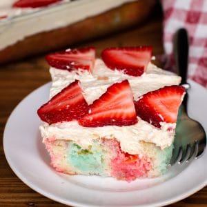 jello poke cake with strawberries on top.