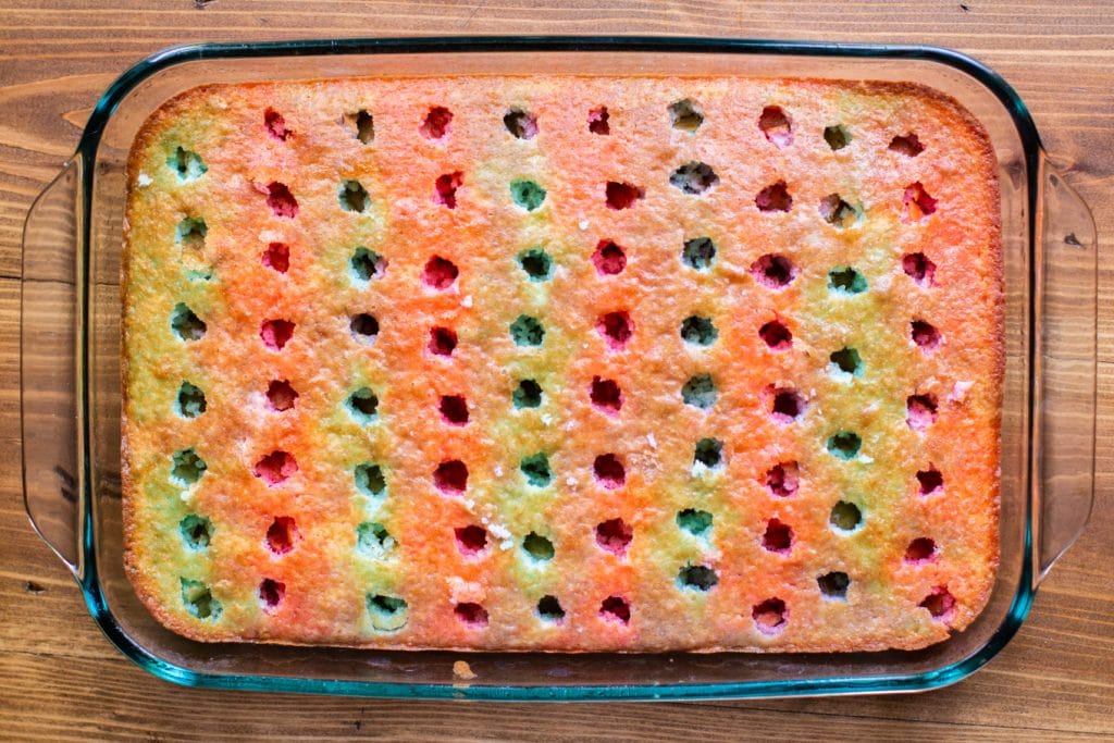 white cake with holes poked in it and jello poured over.