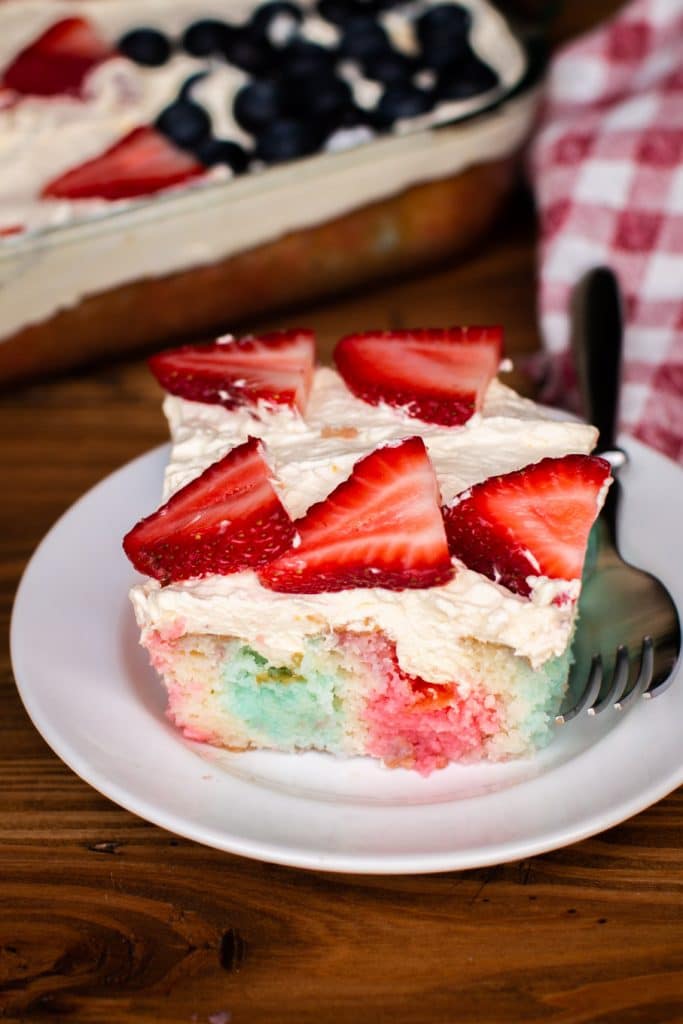 slice of jello poke cake with fork on the side