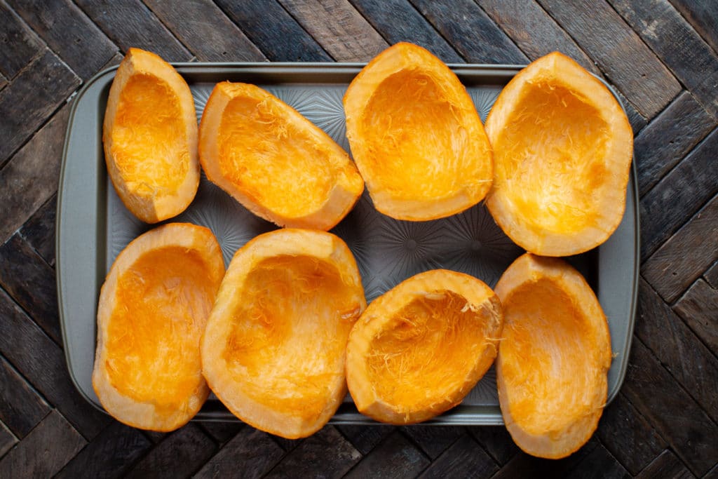 slices of pumpkin, uncooked on a sheet pan