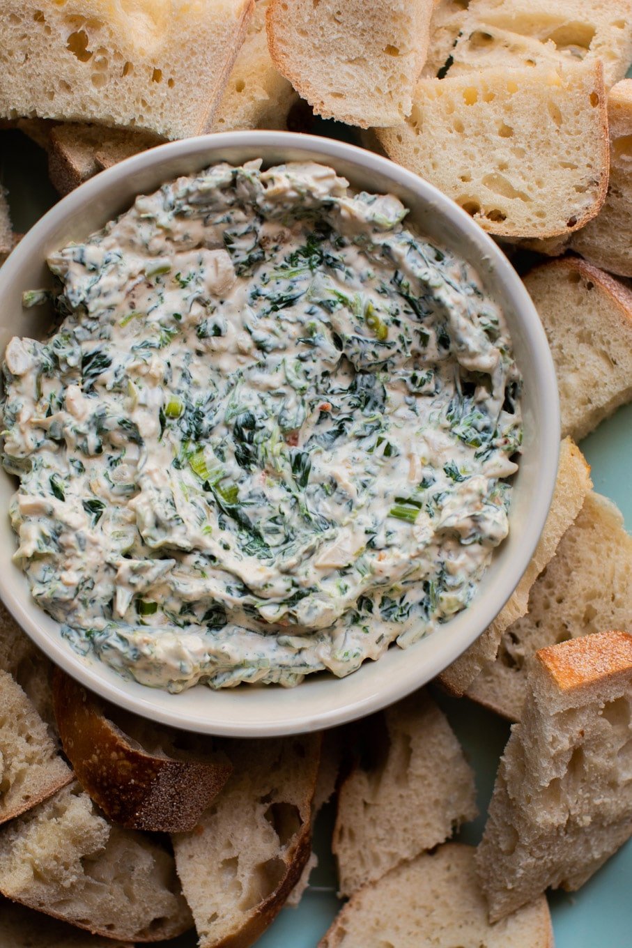 bowl of spinach dip with bread on the side