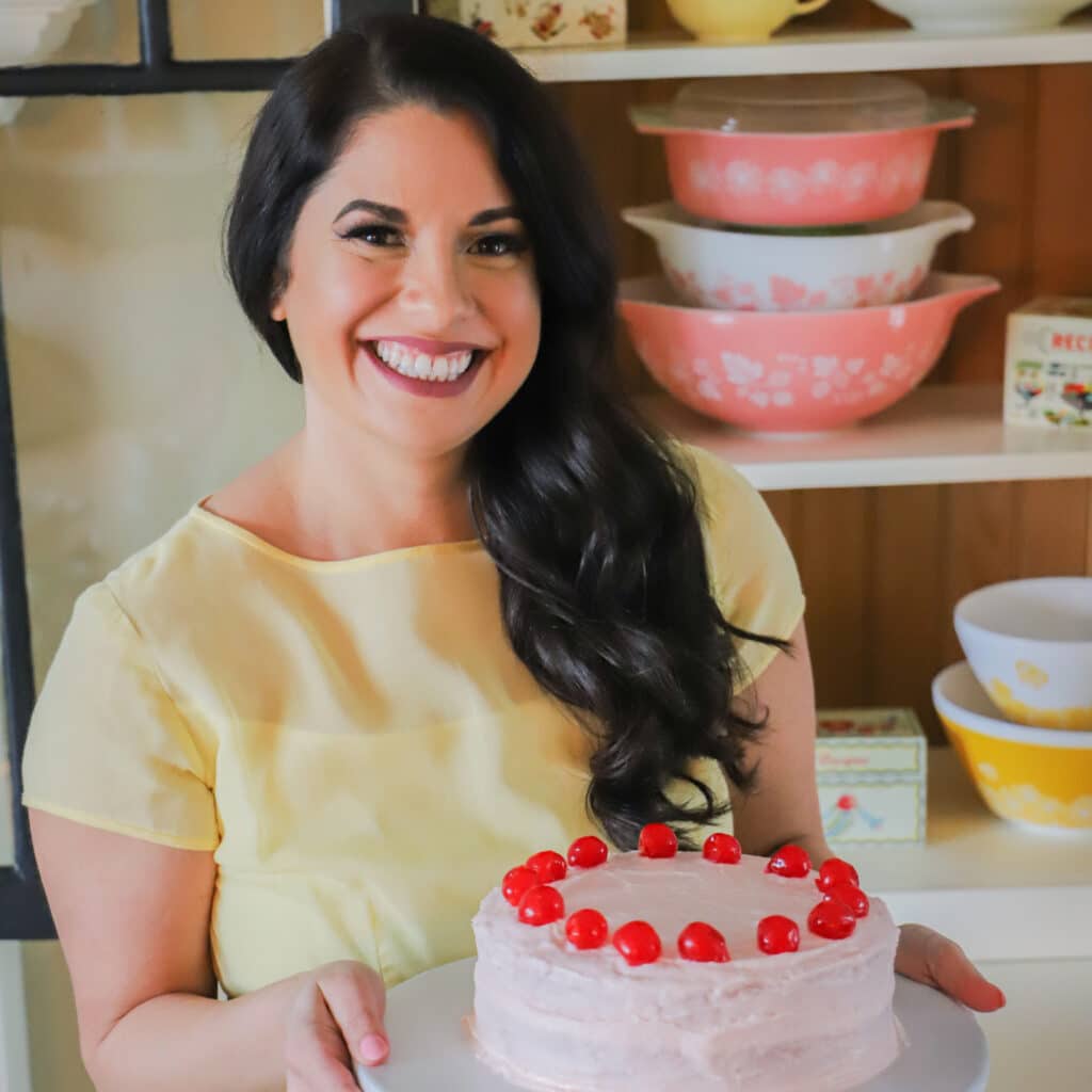 Sarah Olson holding cherry cake with pyrex in the background.