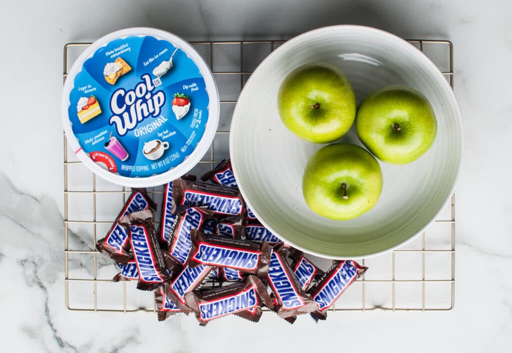 apples, cool whip and snickers bars on table