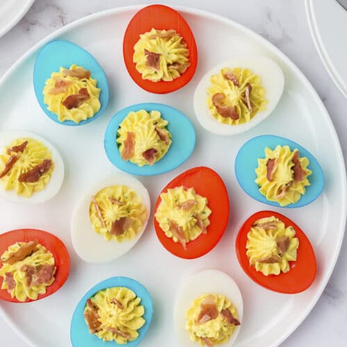 round plate of red white and blue eggs with bacon and paprika