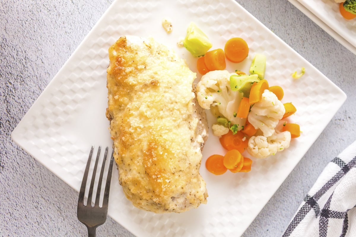 mayonnaise parmesan chicken on plate with vegetables