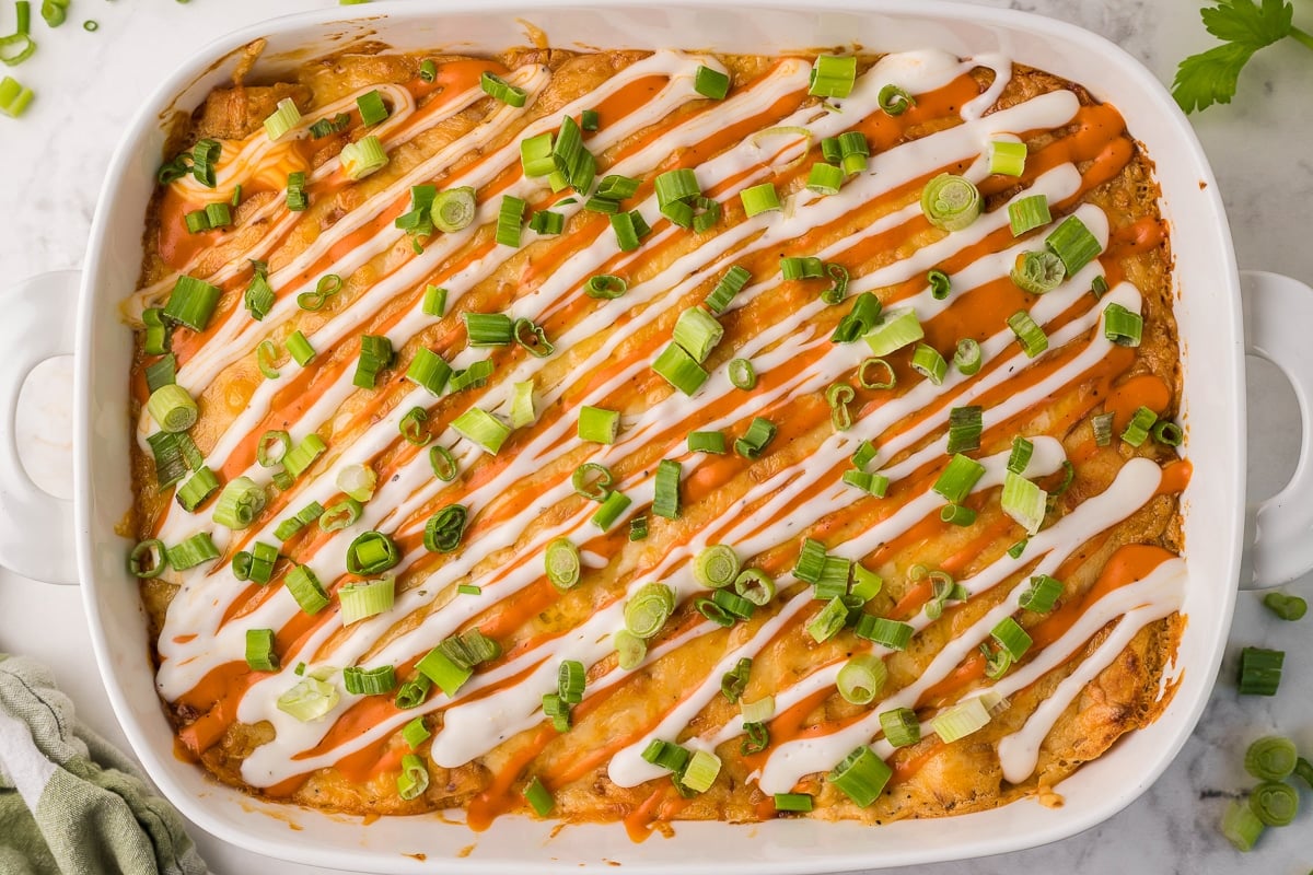 tray of buffalo enchiladas with green onion on top.