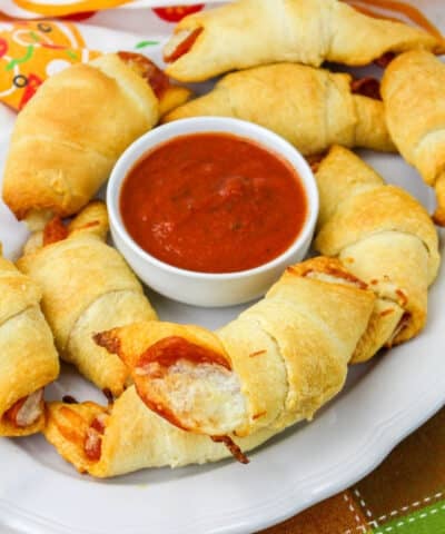 Plate with pizza rolls and marinara in the middle.