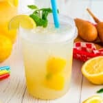State fair lemonade in a plastic jar with a lemon slice and mint garnish on top.